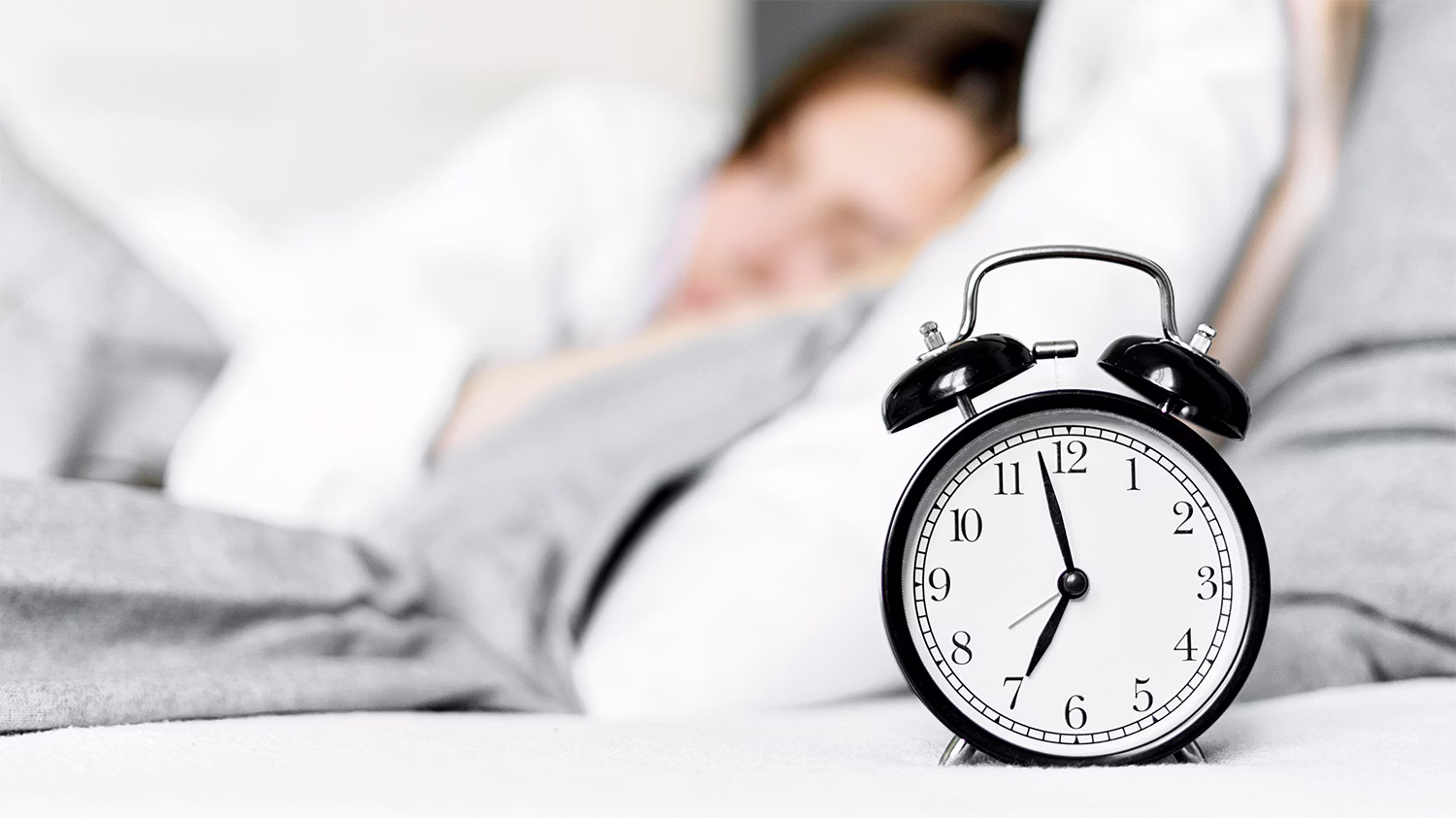 primer plano de un reloj con una chica descansando de fondo